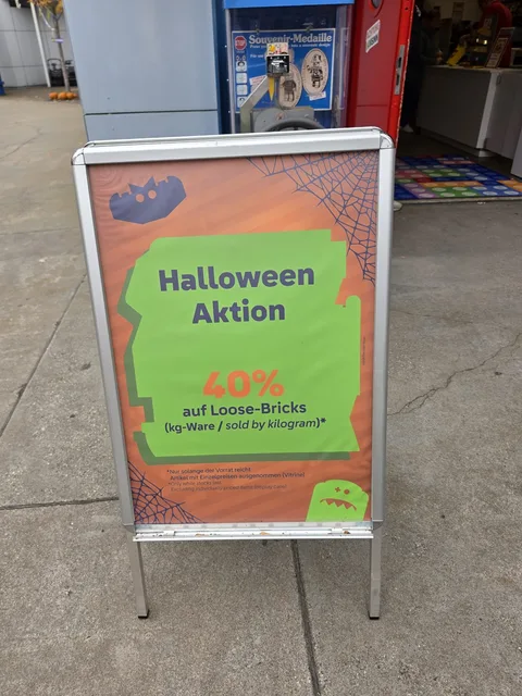 Ein Aufsteller vor dem Shop: „Halloween Aktion: 40% auf Loose-Bricks (kg-Ware / sold by kilogram)“, nur solange der Vorrat reicht, Artikel mit Einzelpreisen in der Vitrine ausgenommen