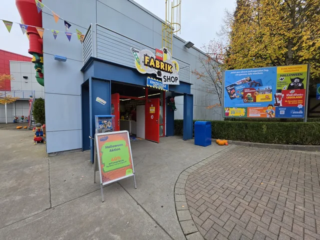 Der Eingang zum LEGO Fabrik Shop mit dem Schild „Einzelteile / Pick a Brick“ und einer Halloween-Aktionstafel davor