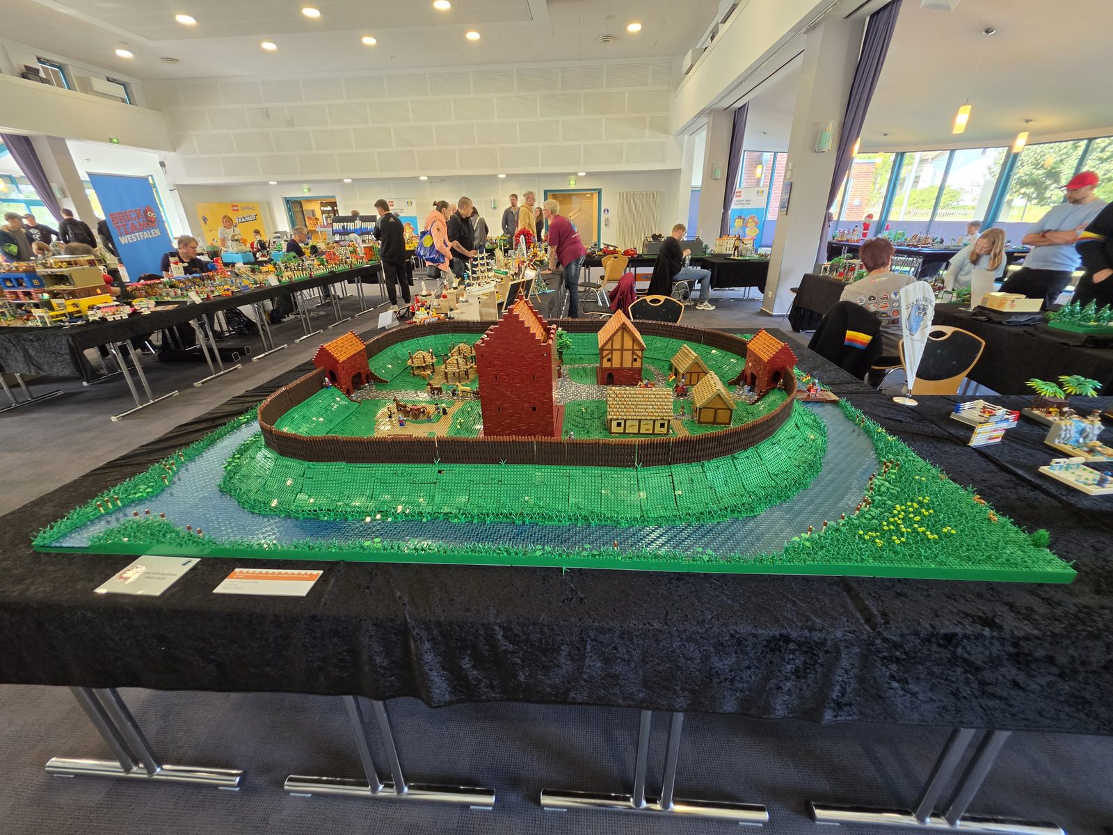 Blick in die Halle des Hamme Forums: im Vordergrund ein Ringwalldorf hinter einer Palisade mit Wassergraben, dahinter die Ausstellungstische und Besucher